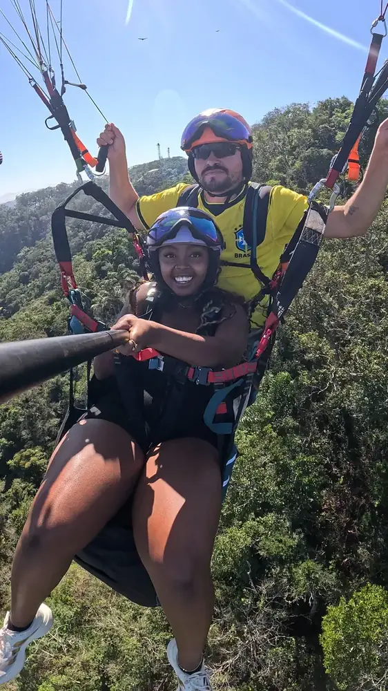 Instrutor e passageiro durante voo de parapente em Niterói, RJ
