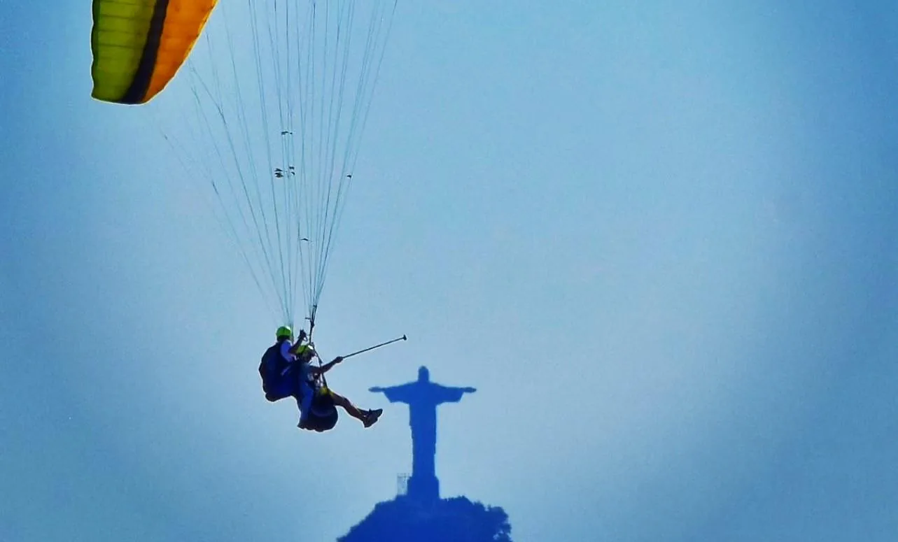 Parapente com o Cristo Redentor ao fundo, visto de Niterói